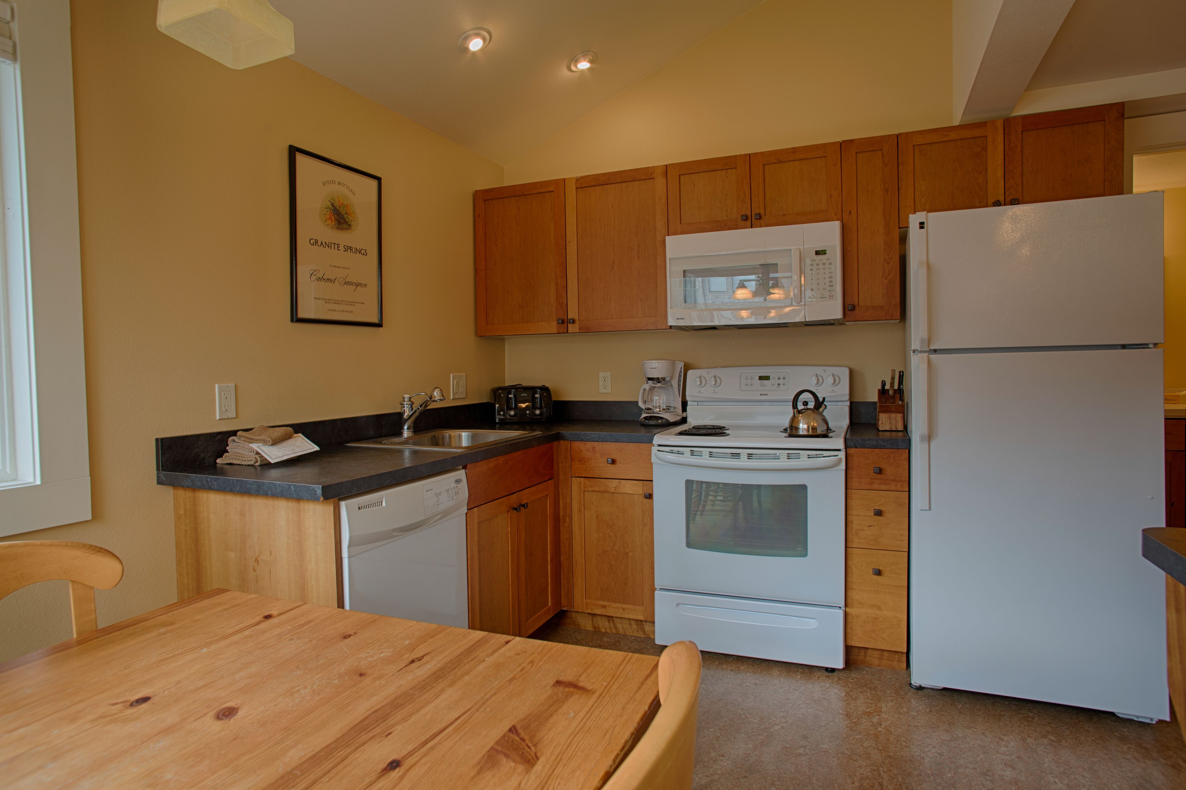 A kitchen with wooden cabinets, a microwave, a stove, and a refrigerator.