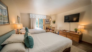A hotel room with two beds, a TV, a desk with a chair, and a window with curtains. - Somerset Inn & Suites (Ephraim)