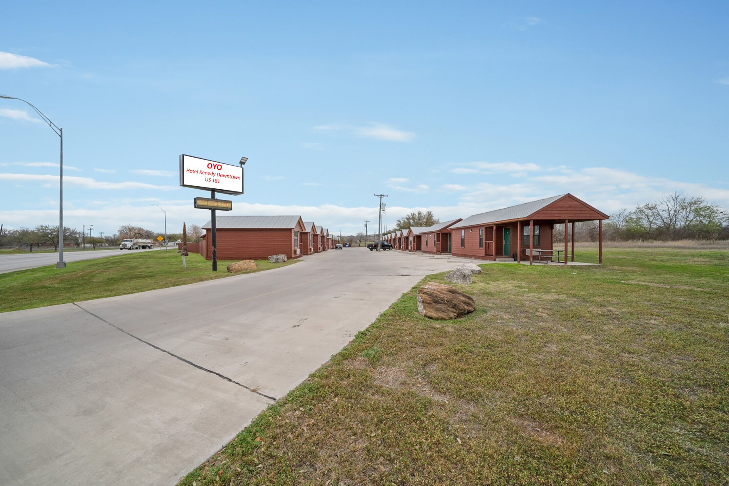 A row of red-roofed buildings with a sign for OYO Hotel Kennedy Downtown US 181.