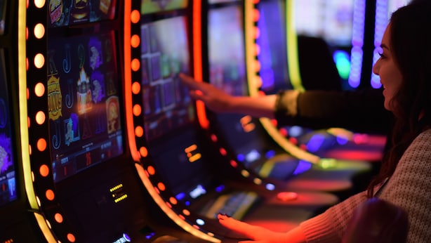 Une personne utilisant une console de jeux dotée d’écrans et de boutons rétroéclairés.