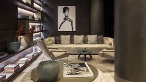 A modern living room with a sofa, coffee table, and bookshelves. - ME Milan - Il Duca (Milan)