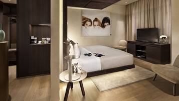 Una habitación de hotel moderna con una cama, un televisor, un escritorio y una silla.