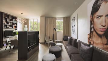 A modern living room with a flat-screen TV, a bookshelf, a sofa, and a large painting.