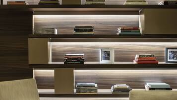 A modern living room with a built-in bookshelf, two armchairs, and a coffee table.
