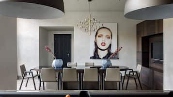 A modern dining area with a pool table, dining chairs, and a chandelier.