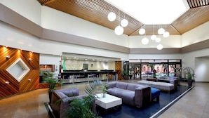 A spacious lobby with a reception desk, seating area, and a piano. - Hotel Princesa Louçã (Belém)