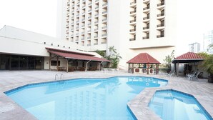A swimming pool with lounge chairs and umbrellas, surrounded by high-rise buildings. - Hotel Princesa Louçã (Belém)