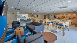 A modern hotel lobby with seating areas, a kitchen, and a reception desk. - City Express by Marriott Apizaco (Apizaco)
