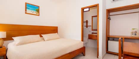 Un dormitorio con una cama de madera, una mesita de noche, un escritorio y un armario.