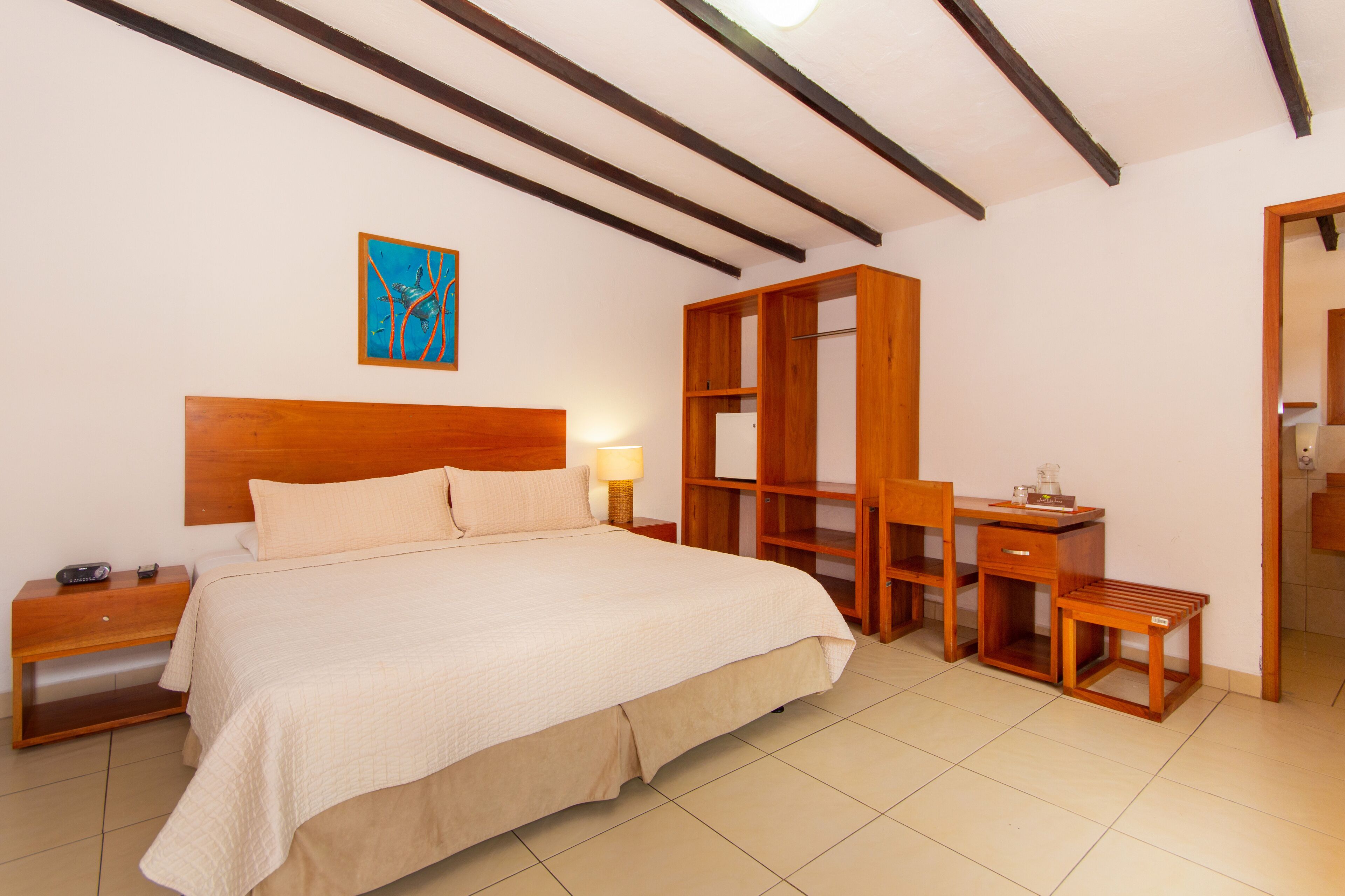 Une chambre à coucher avec un grand lit, des tables de chevet en bois, un bureau et une armoire.