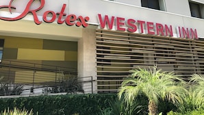 The exterior of the Rotel Western Inn, featuring a modern facade with large signage and a series of windows. - Rotex Western Inn (Los Angeles)
