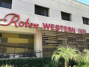 Experience the contemporary charm of Rotes Western Inn, featuring a modern design with a prominent sign and beautifully landscaped surroundings.