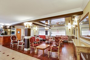 Experience the classic elegance of our lobby, featuring a reception desk, plush seating area, and large mirror.