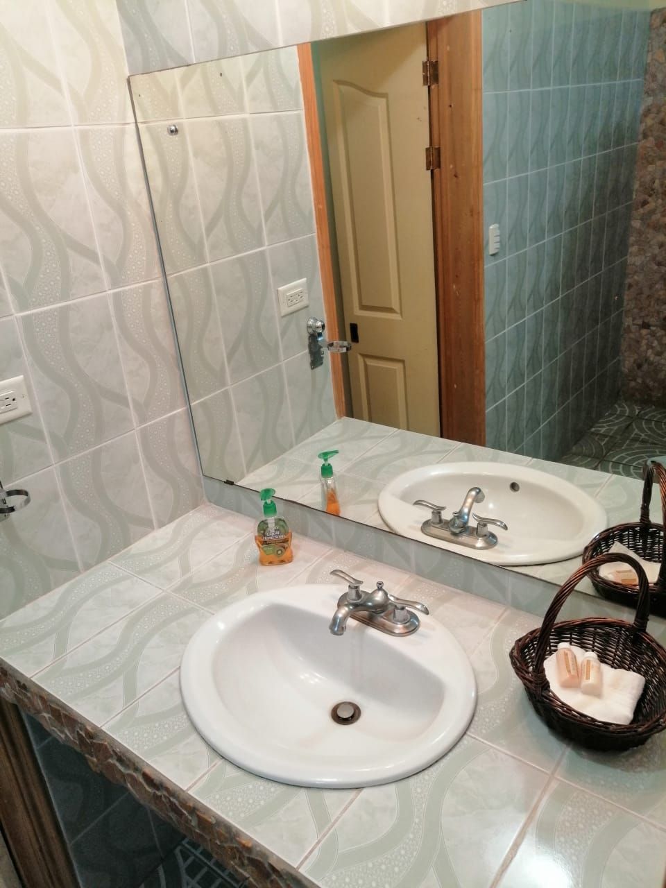 Un baño con dos lavamanos, un espejo y una puerta.