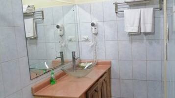A bathroom with a toilet, sink, and mirror.