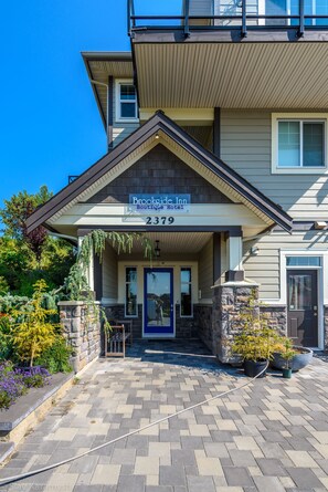 A two-story building with a sign reading "Brookside Inn Boutique Hotel" at the entrance. - Brookside Inn Boutique Hotel (Abbotsford)