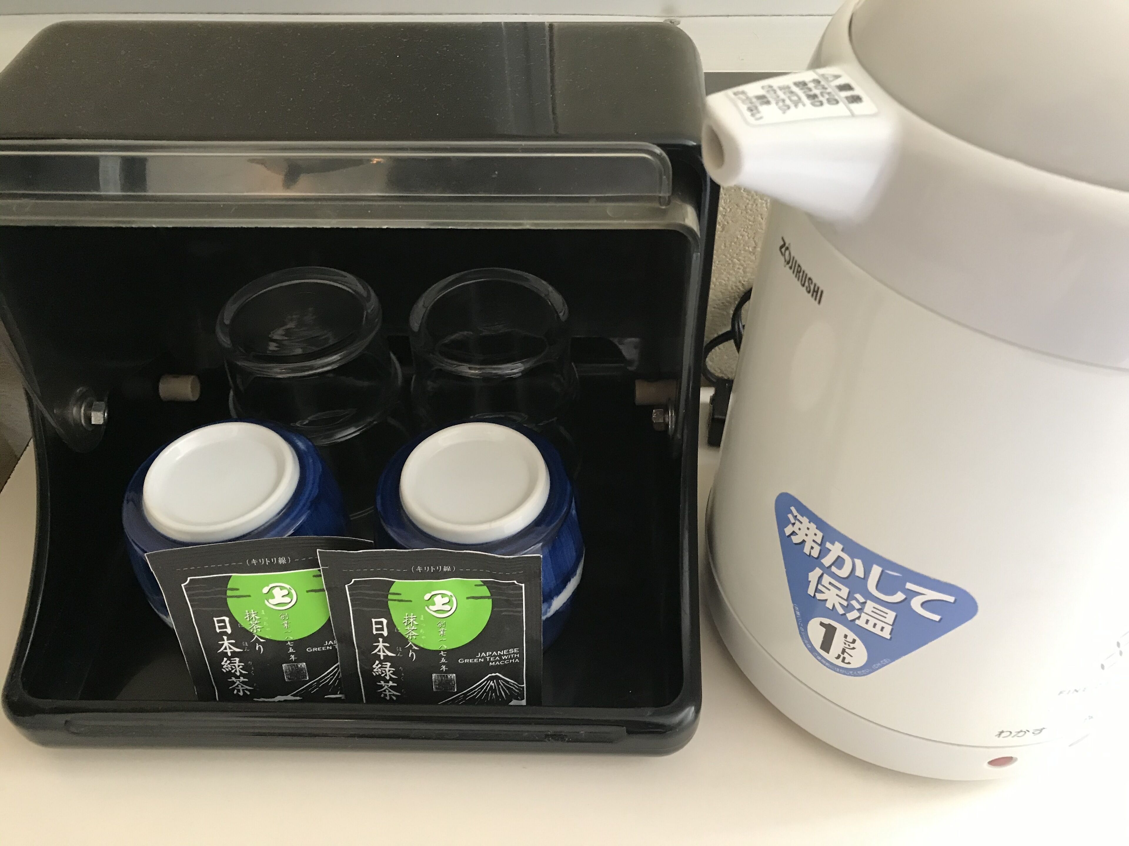 A Japanese tea set with a tea maker and four cups.