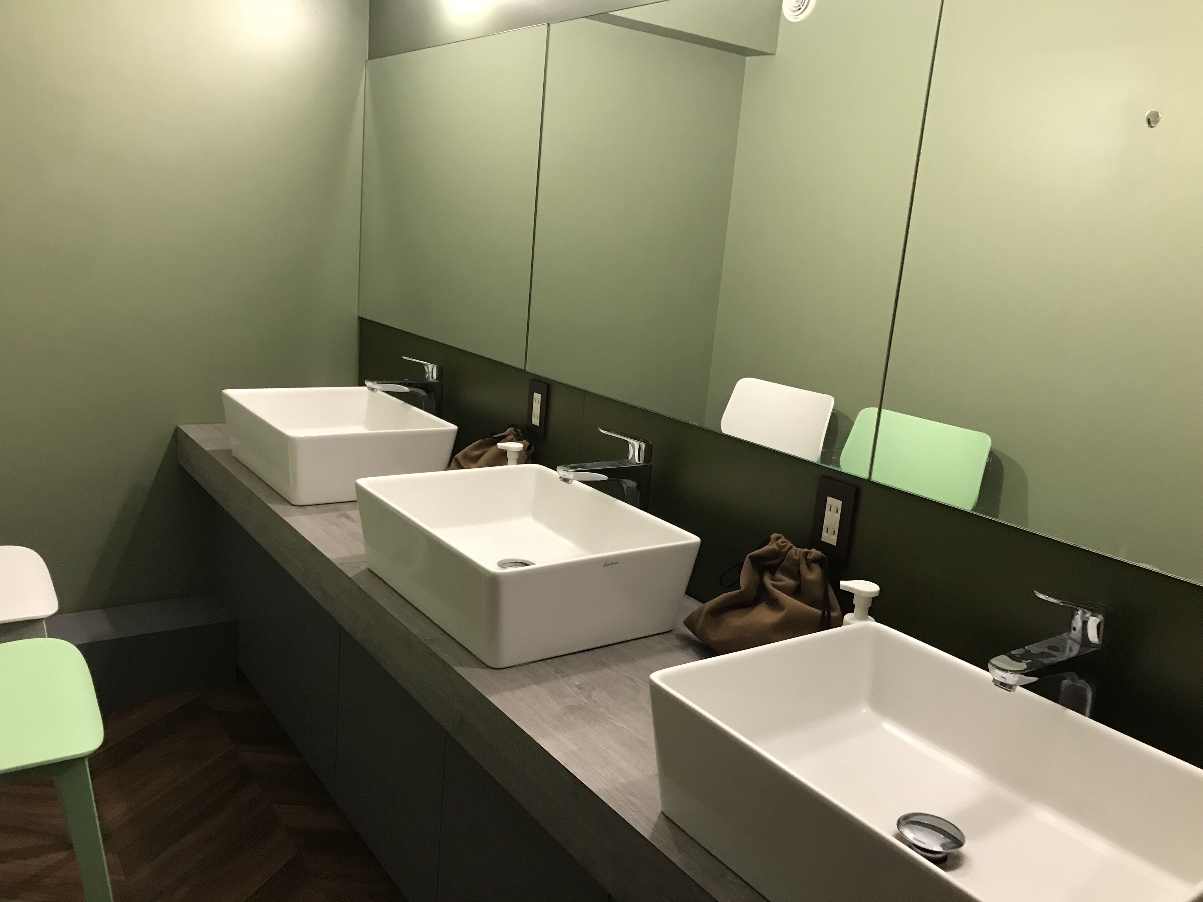 A modern bathroom with two sinks, a mirror, and a towel rack.