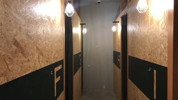 A hallway with wooden walls and black panels marked with letters.