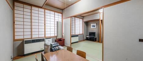 A traditional Japanese-style room with tatami flooring, a low wooden table, and sliding shoji doors.