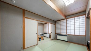 A traditional Japanese room with tatami flooring, sliding doors, and a view through shoji screens. - Tabist THE GREEN OTARU (Otaru)