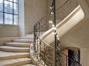 A spiral staircase with ornate metal railings and a series of steps leading upwards. - Fontevraud L'Ermitage (Fontevraud-l'Abbaye)