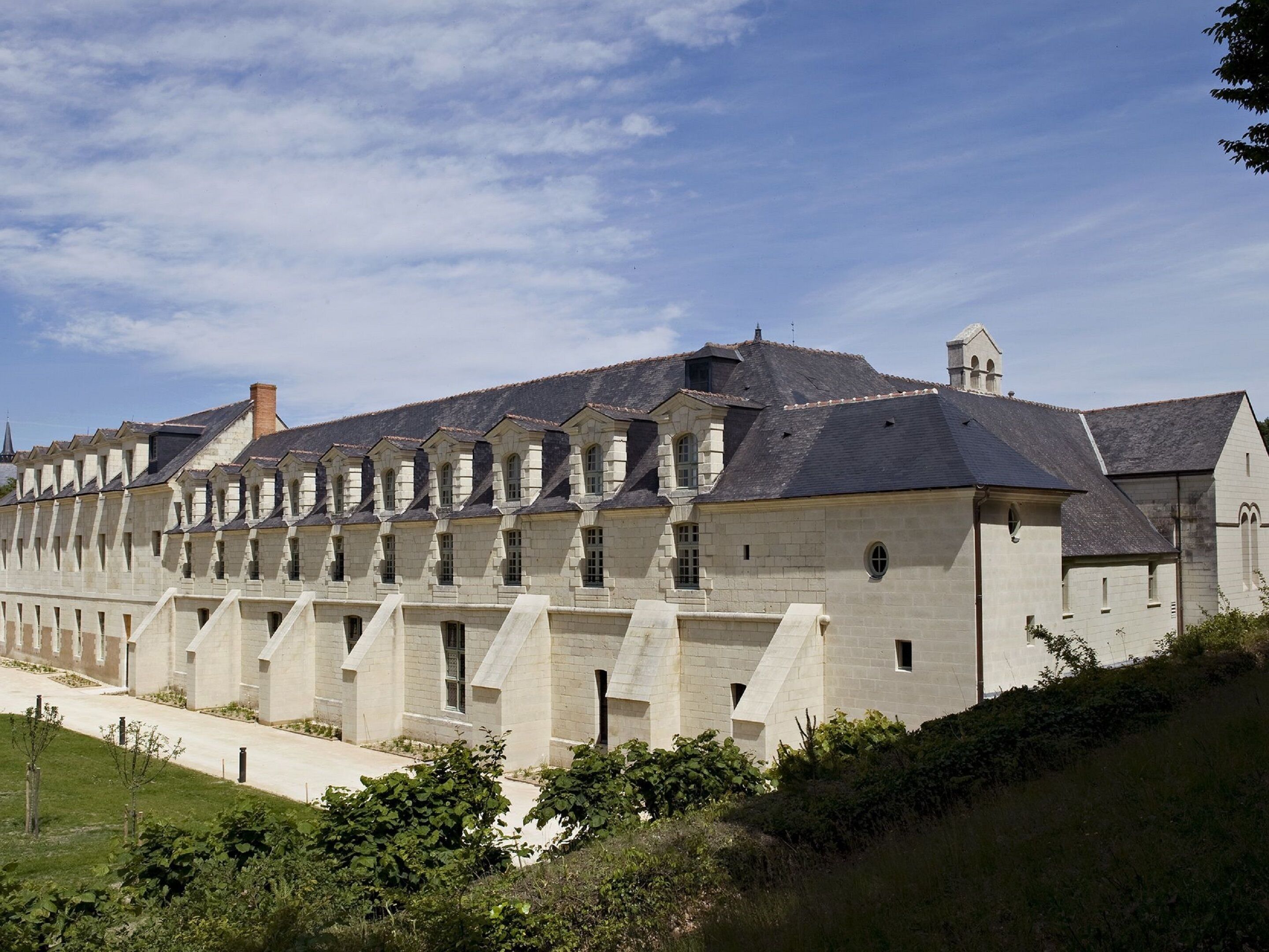 A large, historic stone building with multiple wings and a central tower.