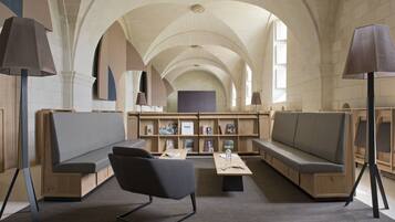 A library with high arched ceilings, wooden bookshelves, and seating areas.