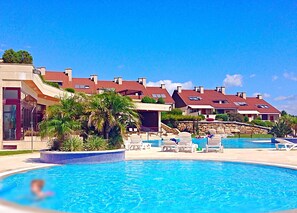 Una piscina cubierta, una piscina al aire libre, tumbonas
