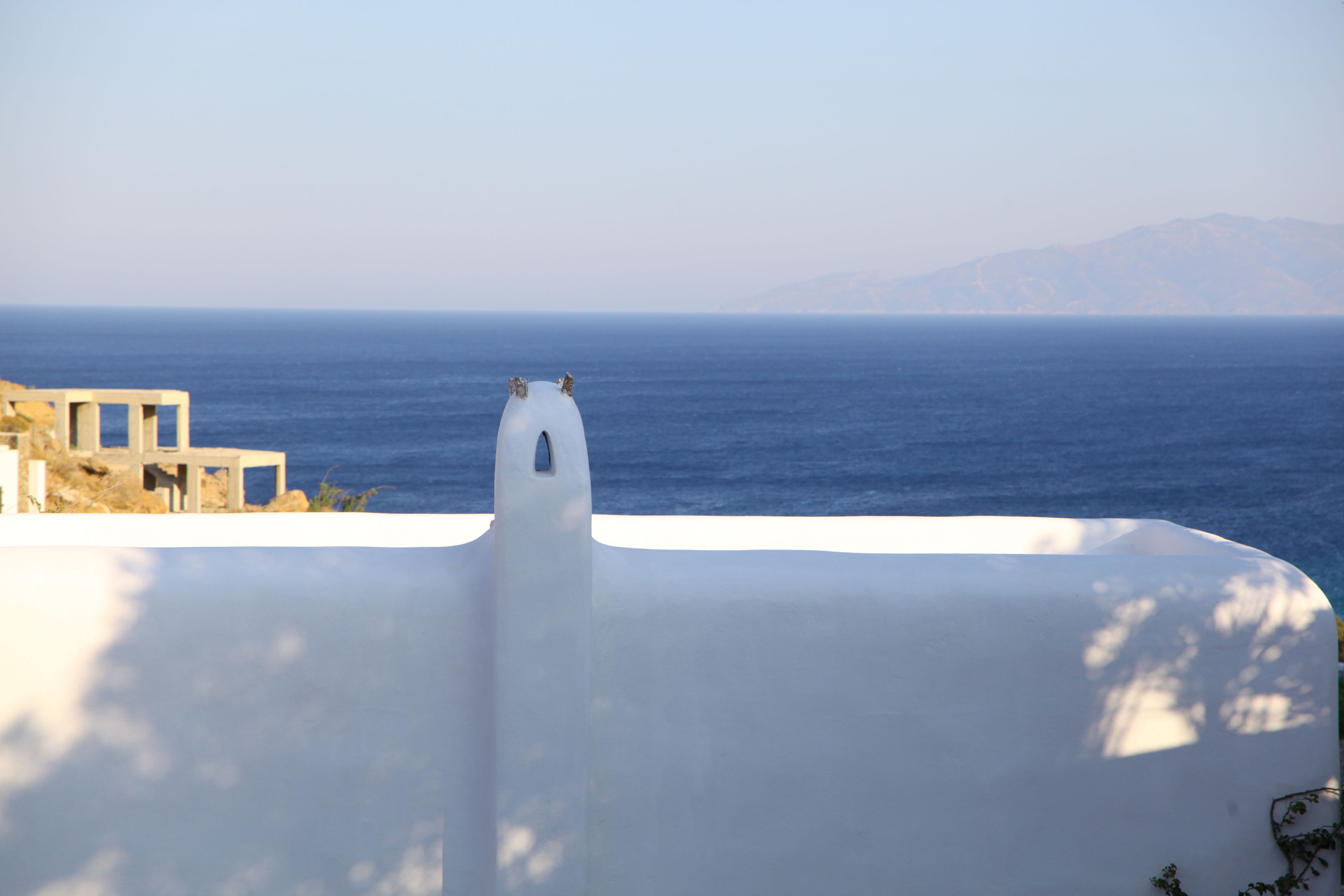 Un edifici blanc amb un balcó que dona al mar.