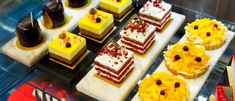 A display of various desserts in a glass case.