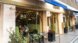 A restaurant with outdoor seating, a blue awning, and a sign reading 'OLIVIER.' - Ibis Pilar (Villa Rosa)