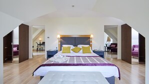 A spacious bedroom with a large bed, a desk, and a chair.