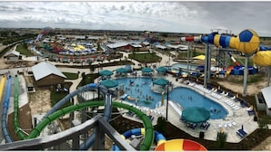 A water park with multiple pools, slides, and a large water slide structure. - Courtyard Houston Katy Mills (Katy)