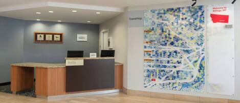 A reception desk with a "Hello" sign, a map of Billings, MT, and a welcome sign.
