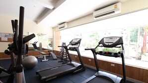 A gym with treadmills, a stationary bike, and a rowing machine. - KC Place Srinakarin (Bangkok)