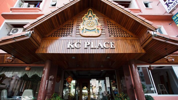 The entrance of KC Place with a wooden facade and a sign above the door. - KC Place Srinakarin (Bangkok)