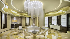 A luxurious lobby with a central seating area, a reception desk, and a large chandelier. - DAMAC Maison Cour Jardin (Dubai)