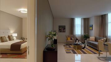 A modern hotel room with a bed, a sitting area with a sofa and armchairs, a coffee table, and a dining table.