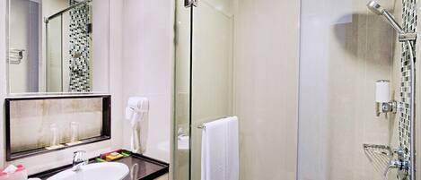 A modern bathroom with a glass-enclosed shower, a sink with a mirror, and a towel rack.