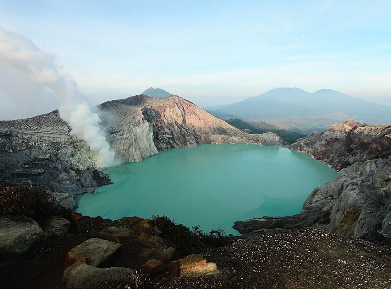 Un lago en cráter volcánico rodeado de terreno escarpado.