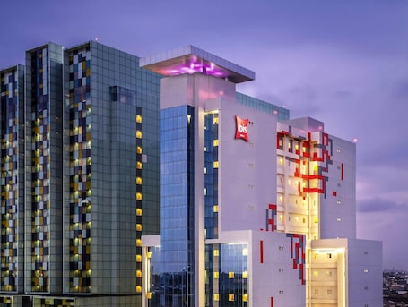 A modern hotel with a distinctive geometric facade, multiple floors, and illuminated windows.