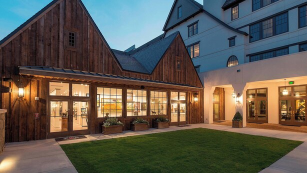 A wooden building with large windows and a well-maintained lawn. - Grand Bohemian Mountain Brook, Autograph Collection (Birmingham)