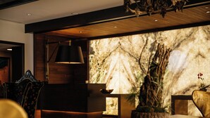 A modern interior with a wooden ceiling, a marble wall, and a reception desk. - Grand Bohemian Mountain Brook, Autograph Collection (Birmingham)