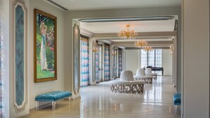 A spacious lobby with a large painting, a bench, a white sofa set, and a chandelier. - Grand Bohemian Mountain Brook, Autograph Collection (Birmingham)