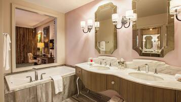 Un baño moderno con tocador doble, espejos grandes y bañera.