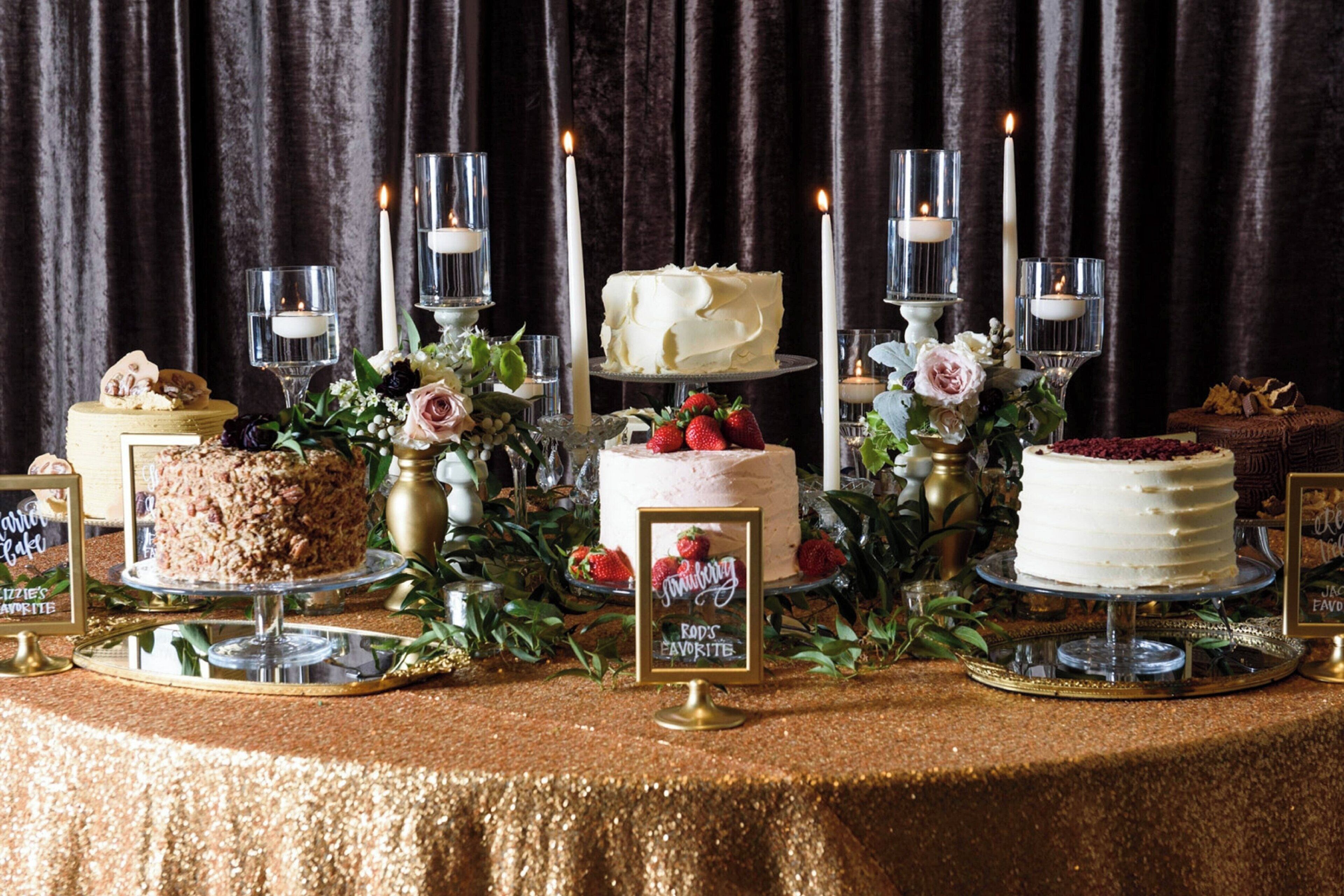 A table with two cakes, candles, and a sign that reads "Kris's Favorites".