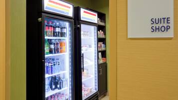 Two beverage refrigerators in a room with a sign indicating a 'SUITE SHOP'.