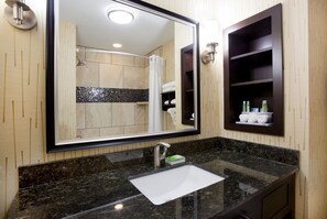 A bathroom with a large mirror, a sink, and a shower. - Holiday Inn Express & Suites Davenport by IHG (Davenport)