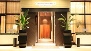 L'entrée de l'hôtel Lagunasuite, qui propose également des services pour les mariages, se distingue par sa façade en bois, ses grands pots de plantes et son intérieur accueillant.